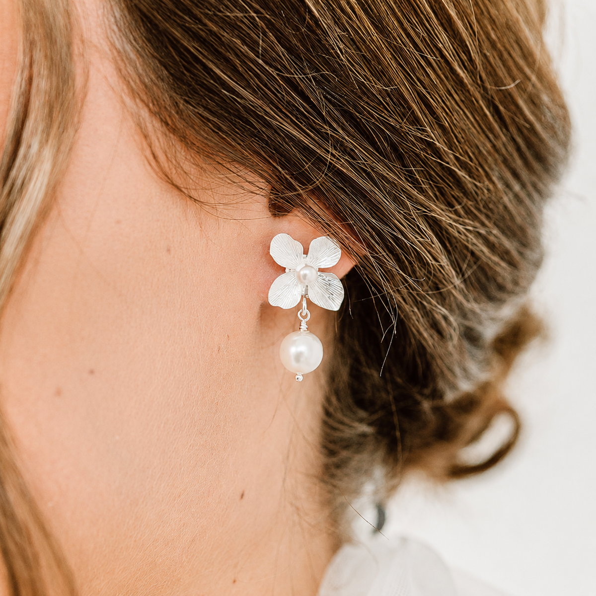 Braut Ohrringe Victoria aus 925 Sterlingsilber mit Blüten und veganen Perlen, Nahaufnahme am Ohr
