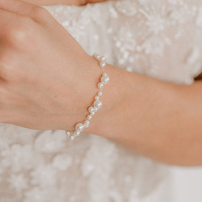 Brautarmband Jasmin mit schwebenden veganen Perlen unterschiedlicher Größe und 925er Sterlingsilber 18K vergoldetem Verschluss, am Model getragen in Nahaufnahme