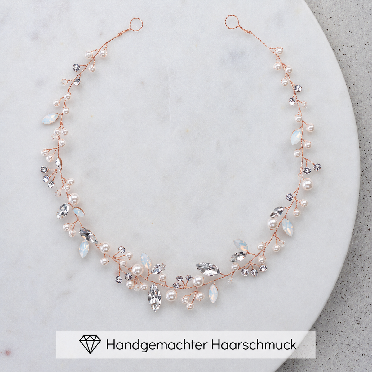 Braut Headpiece Luise in Roségold mit Perlen und Kristallen, liegend auf einer Marmorplatte